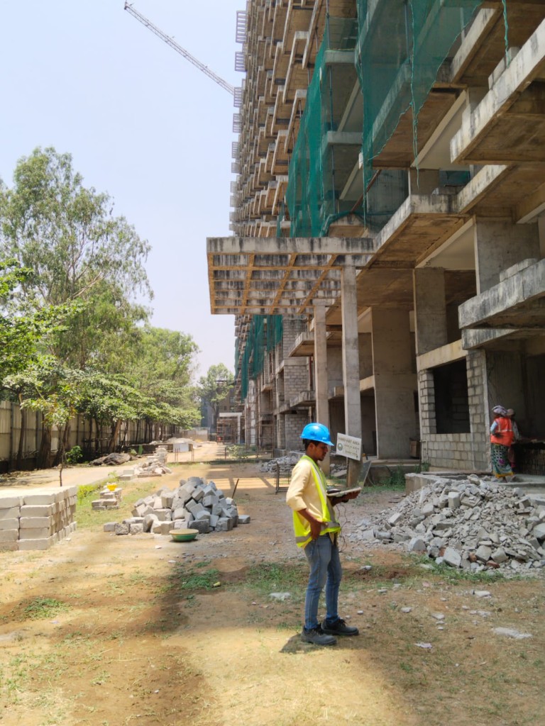 Multi-storey building under construction with site supervisor reviewing plans on site