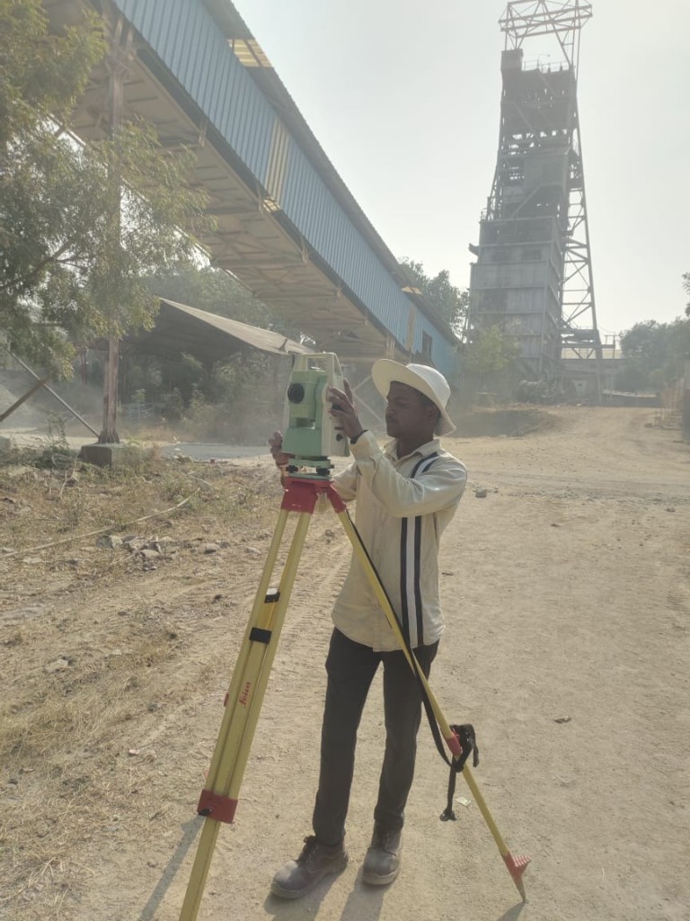 Surveyor operating a total station at an industrial site in Karnataka