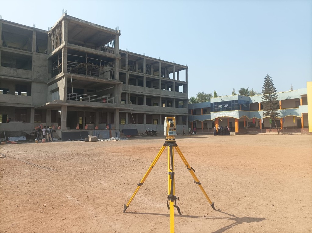 School building construction site with total station setup for layout and survey